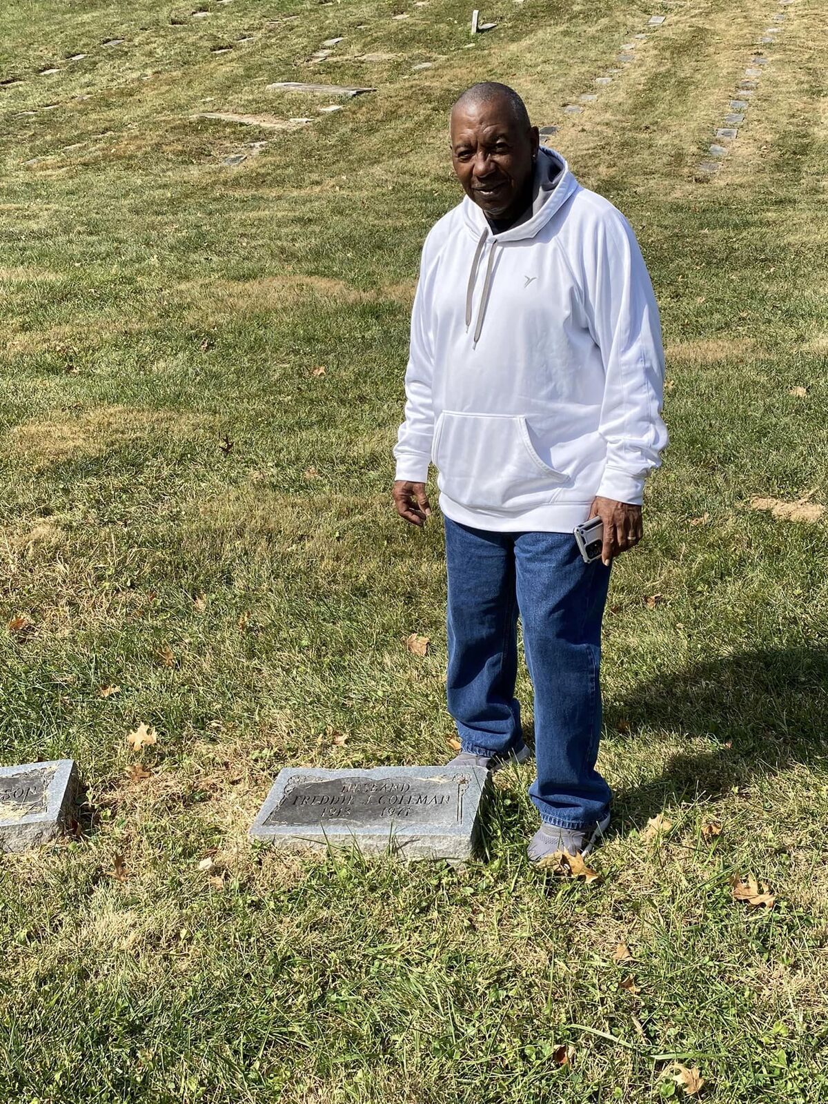 Man posing in front of headstone