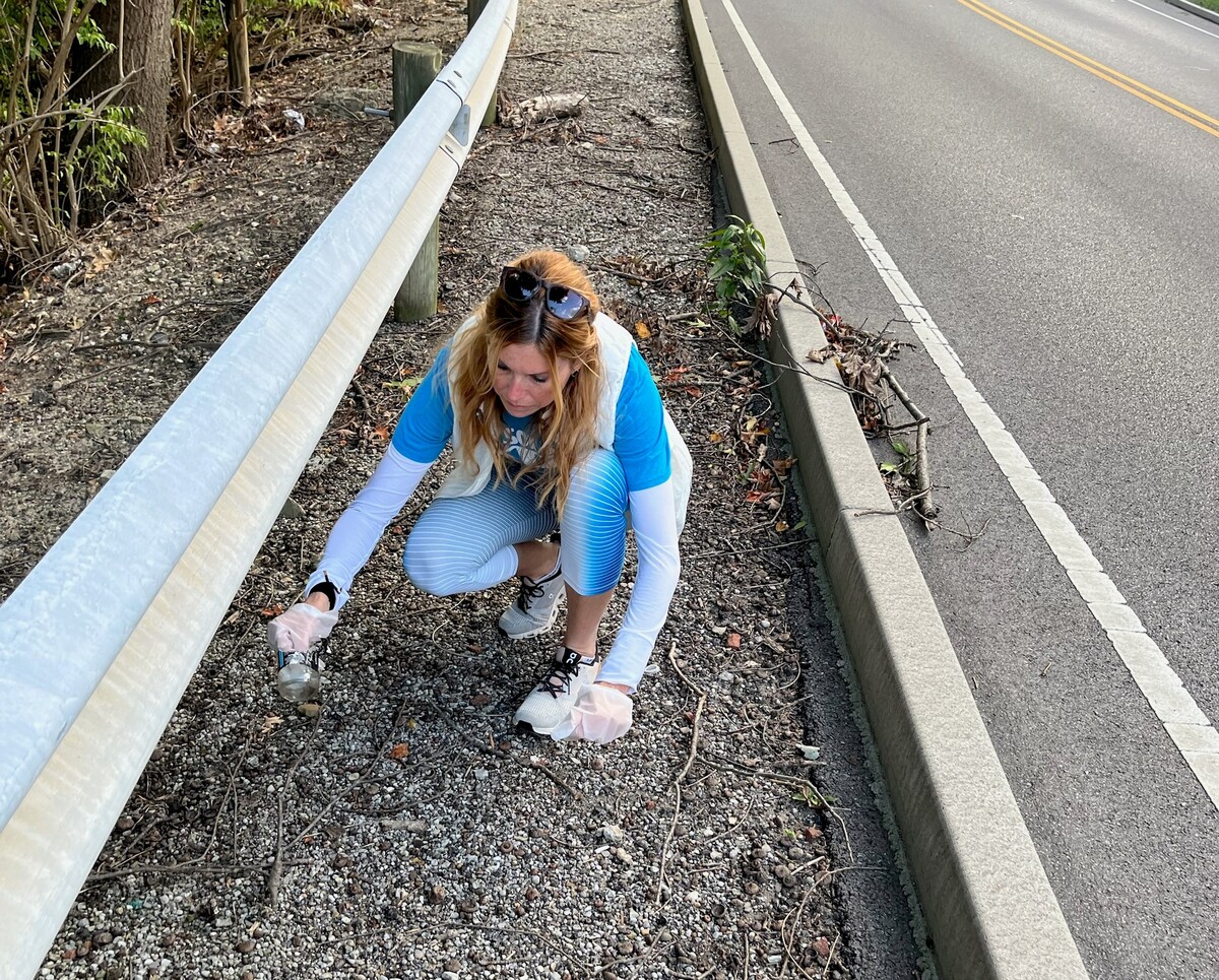 girl cleaning up on side of road