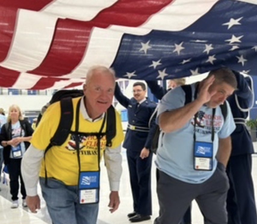 Hornschemeier and Meltebrink walk under a U.S. flag