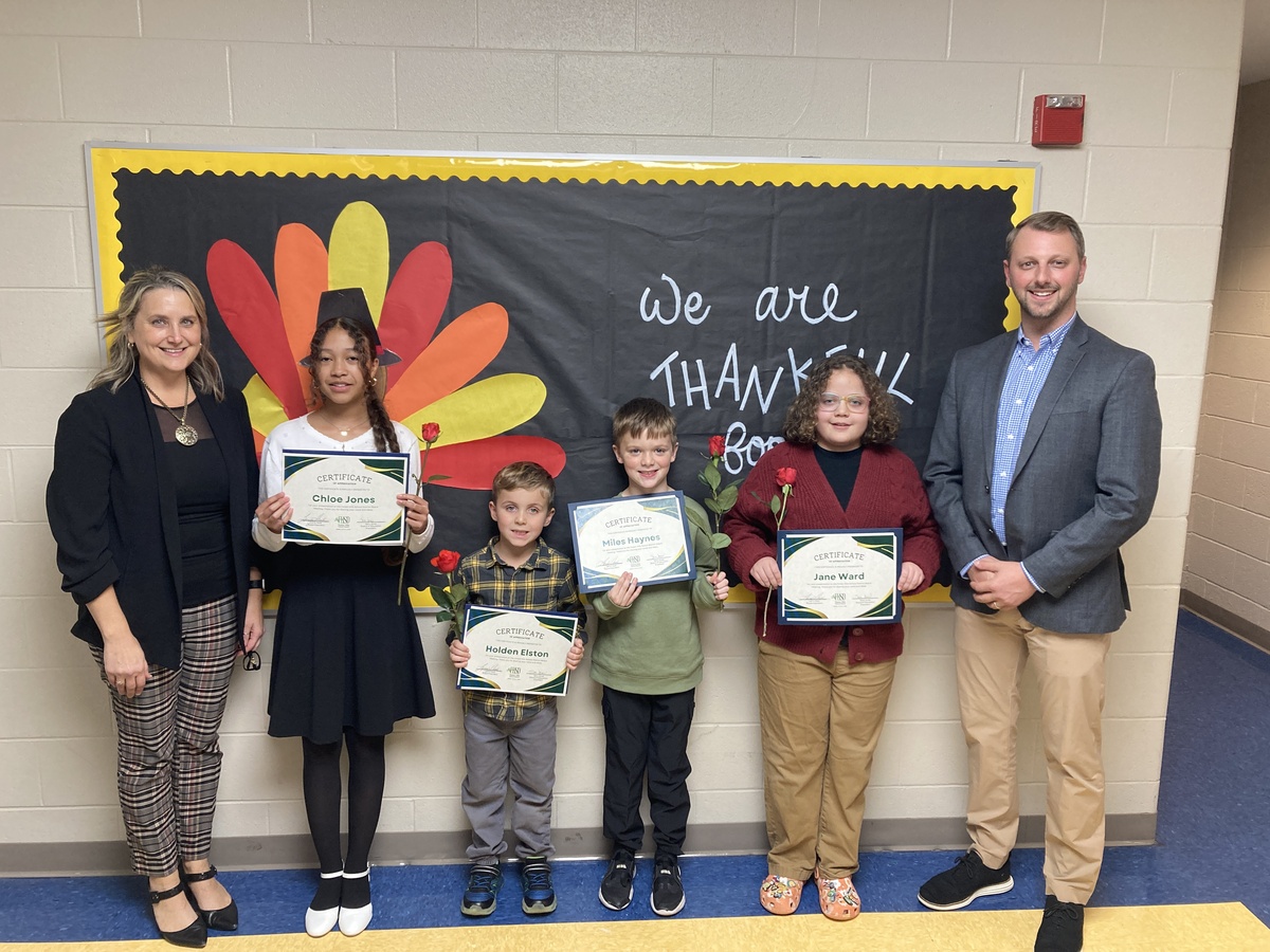 Students pose with their principals while holding certificates of recognition