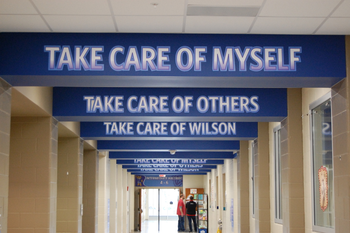 ceiling banners that say "Take Care of Myself", "Take Care of Others", "Take Care of Wilson"